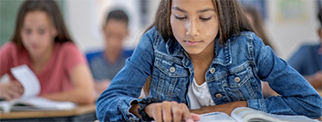 Female student reading a book in a classroom