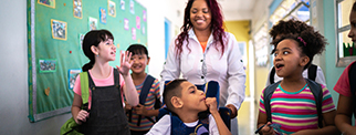 Teacher and students walking in the corridor at school - including a person with special needs